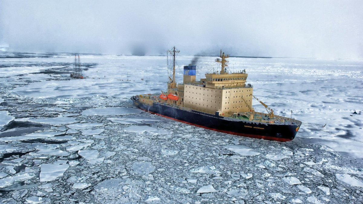 Icebreaker ship cutting through vast frozen ocean, showcasing winter exploration.