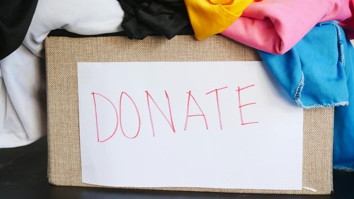 A donation box filled with colorful clothing, symbolizing charity and community support.