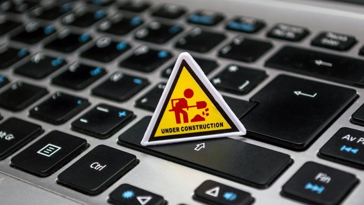 A miniature under construction sign placed on a laptop keyboard symbolizing digital development.
