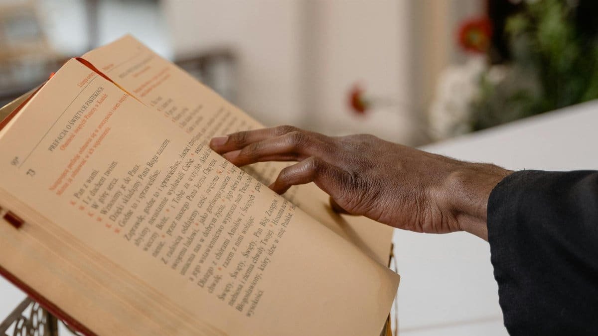 A close-up of a hand reading a religious text, symbolizing engaged spirituality.