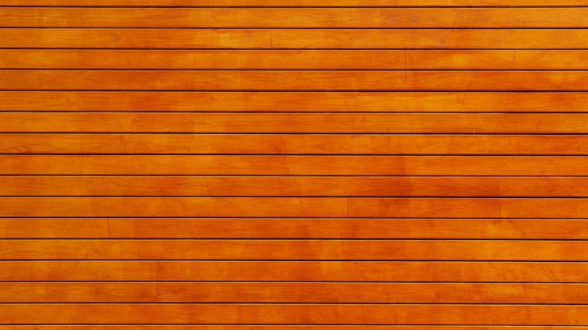 Close-up of a vibrant orange wooden wall texture, ideal for backgrounds.