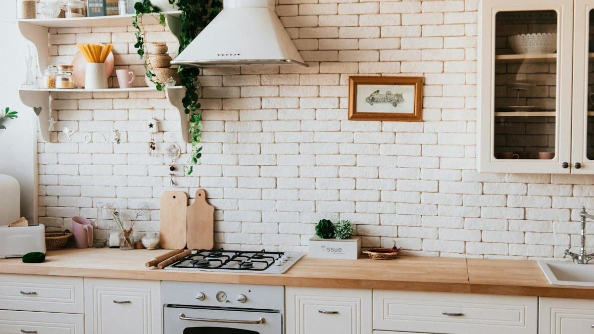 Stylish kitchen interior with modern appliances, wooden counters, and greenery accents.