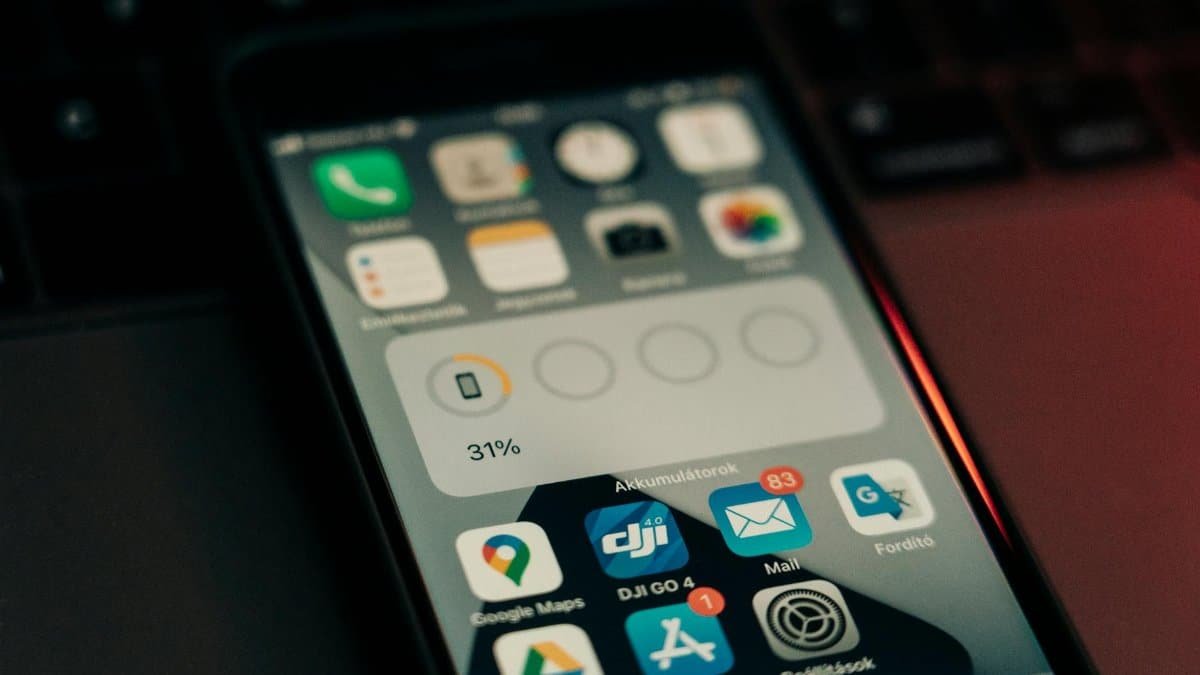 A smartphone with various apps on its screen placed on a keyboard, showing a 31% battery level.