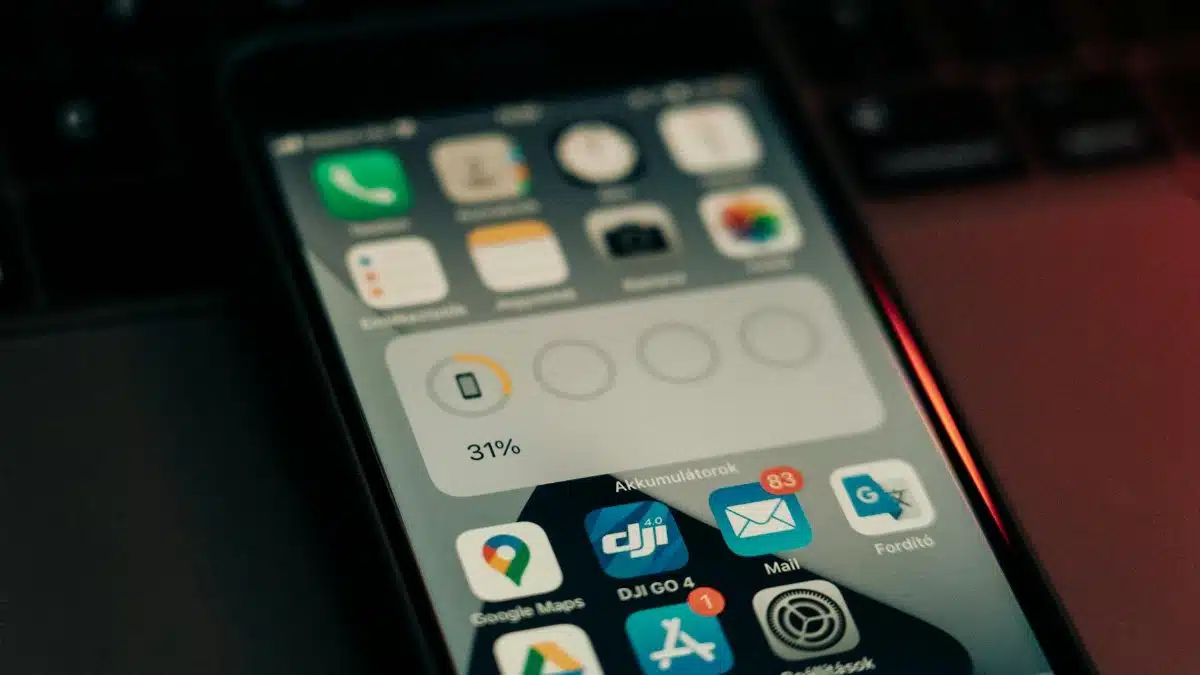 A smartphone with various apps on its screen placed on a keyboard, showing a 31% battery level.