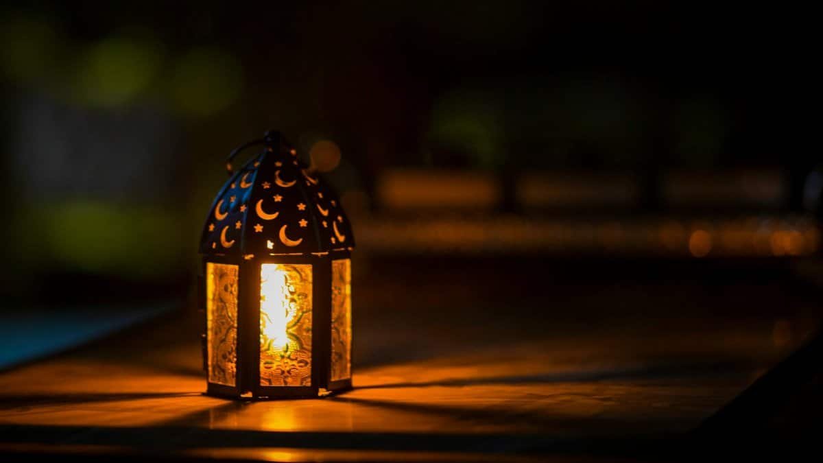 A glowing lantern with crescent motifs creates a warm ambiance for Ramadan or Eid.