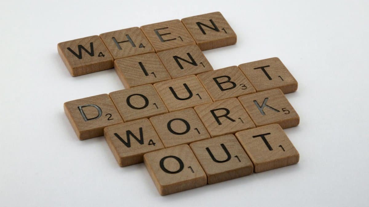 Scrabble tiles arranged to spell a motivational quote on a white background.