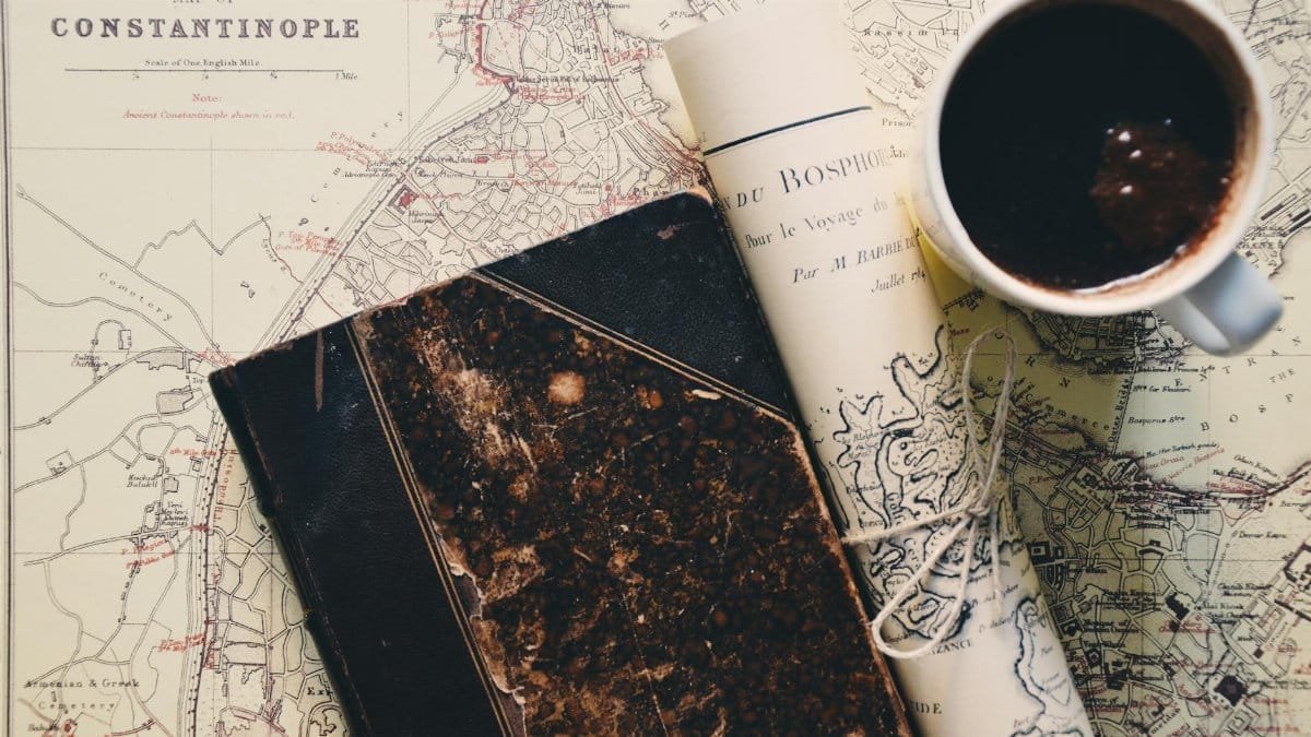 Close-up of a vintage map of Constantinople with a cup of coffee and an old notebook, conveying a travel vibe.