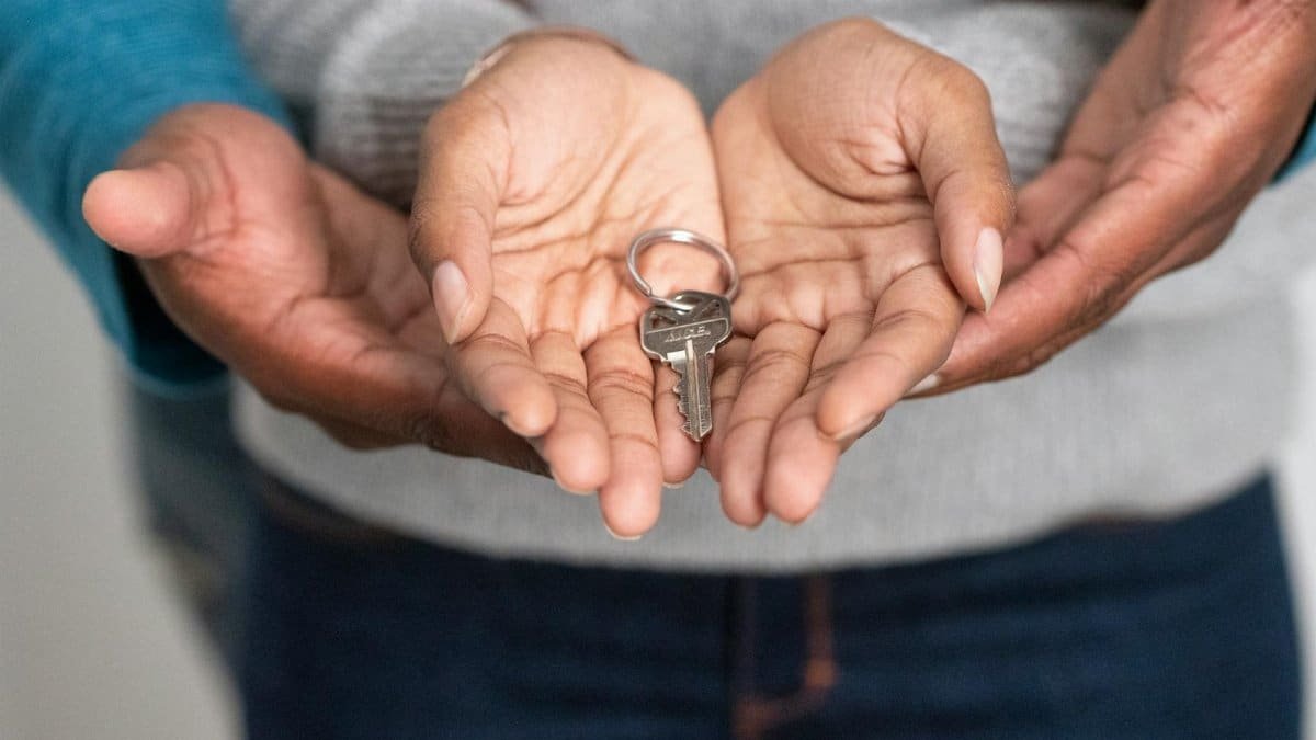 Close-up of hands holding a key, representing new homeownership and property investment.