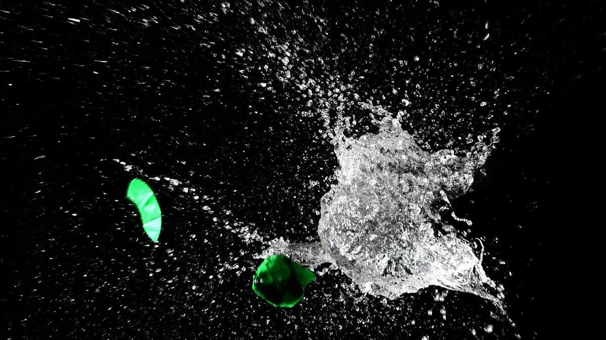 High-speed capture of a water balloon bursting, revealing dramatic splash against a dark background.