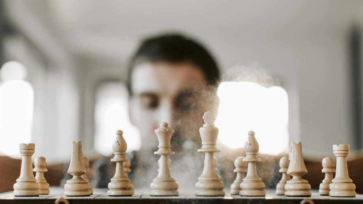 Close-up of a chessboard with chess pieces in action, representing strategy and concentration.