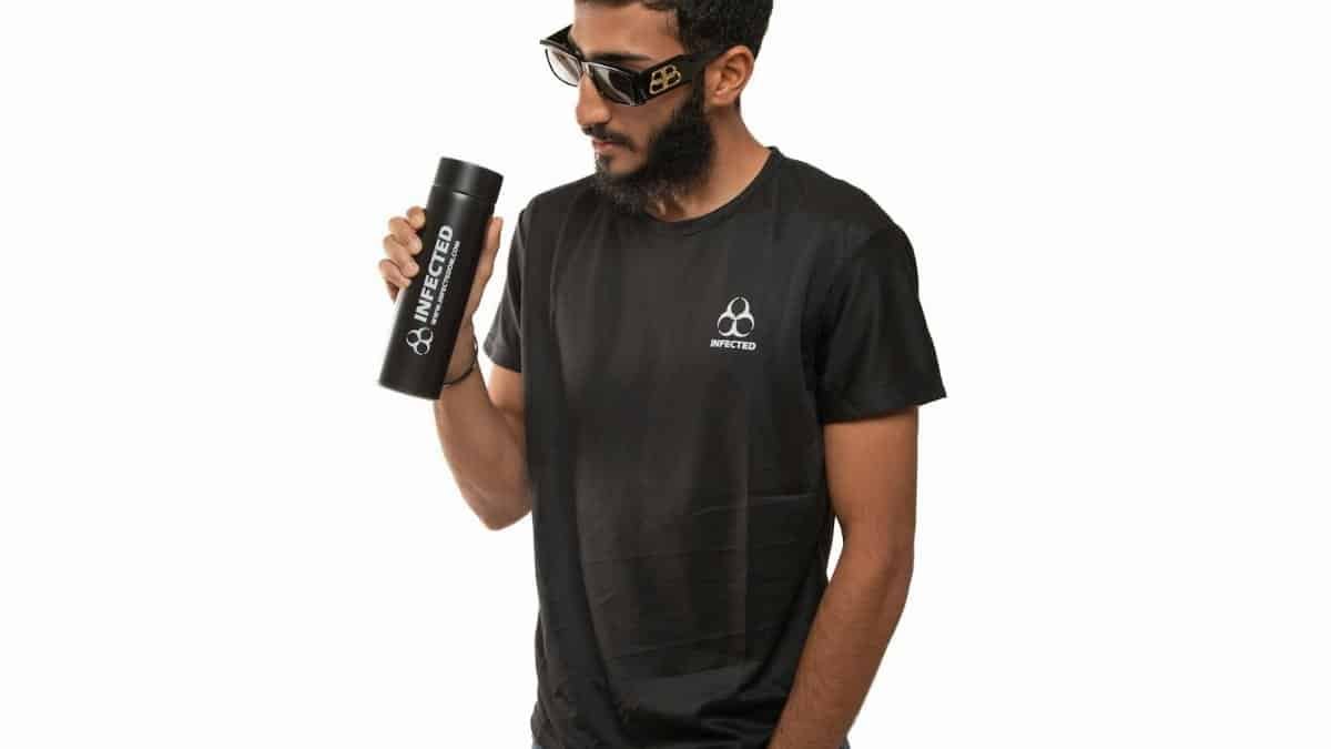 Man wearing stylish black t-shirt and sunglasses holding a thermos.