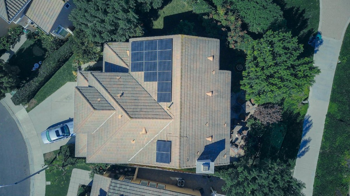 Top-down aerial view of a house with solar panels, showcasing modern renewable energy solutions.