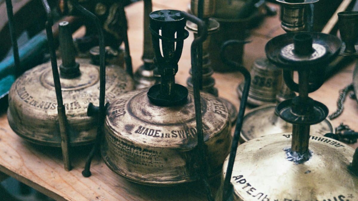 Close-up of vintage Primus stoves on display with intricate engravings, showcasing retro design.