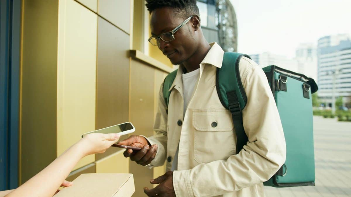 Courier uses smartphone to confirm delivery in urban setting.