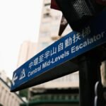 Urban street sign pointing to Central Mid-Levels Escalator in Hong Kong.