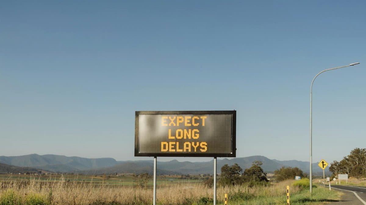 Traffic sign in Gladfield, QLD, advising of long delays ahead on a rural road.