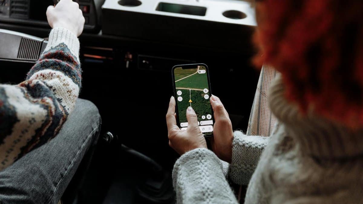 Two people using a navigation app on a smartphone during a road trip