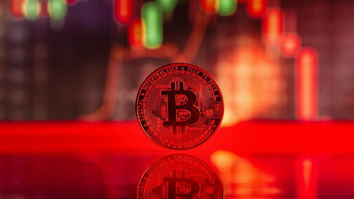 Close-up image of a Bitcoin coin with trading graph reflection, symbolizing cryptocurrency market dynamics.