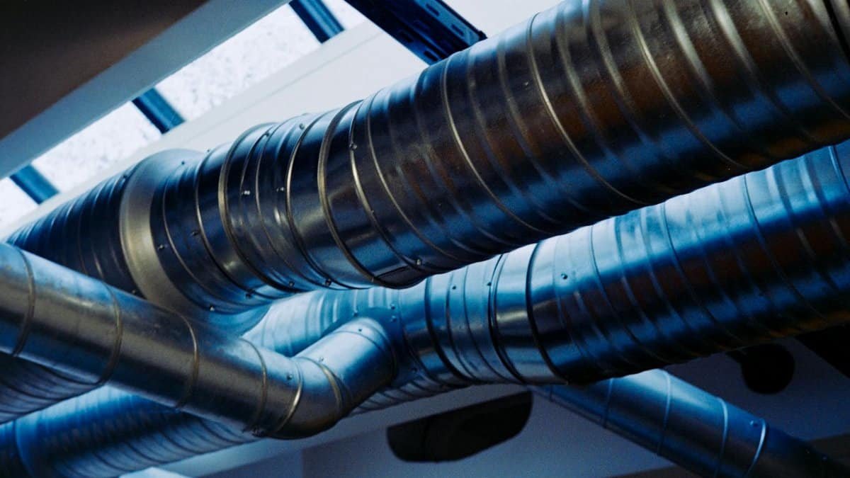 Close-up of a modern metallic ventilation system in an industrial setting.