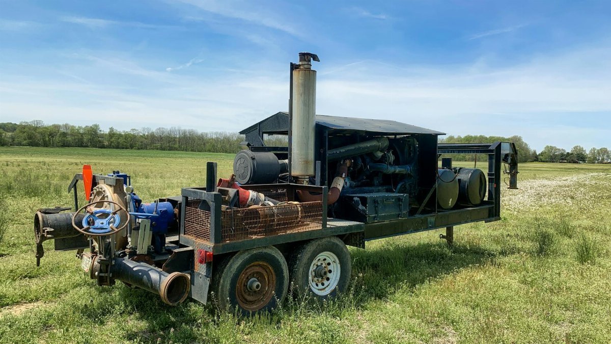 Diesel engine water pump in a Smithville field under clear sky.