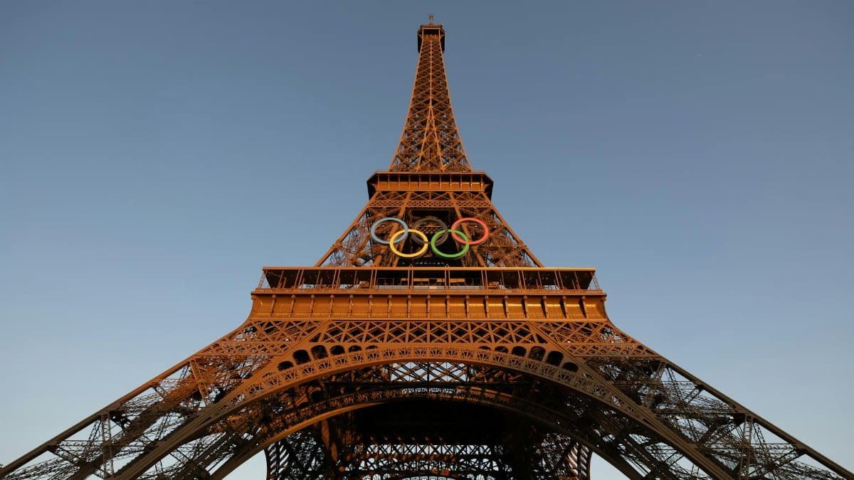 Eiffel Tower adorned with Olympic rings at sunset in Paris, France, offering a stunning view of this iconic landmark.