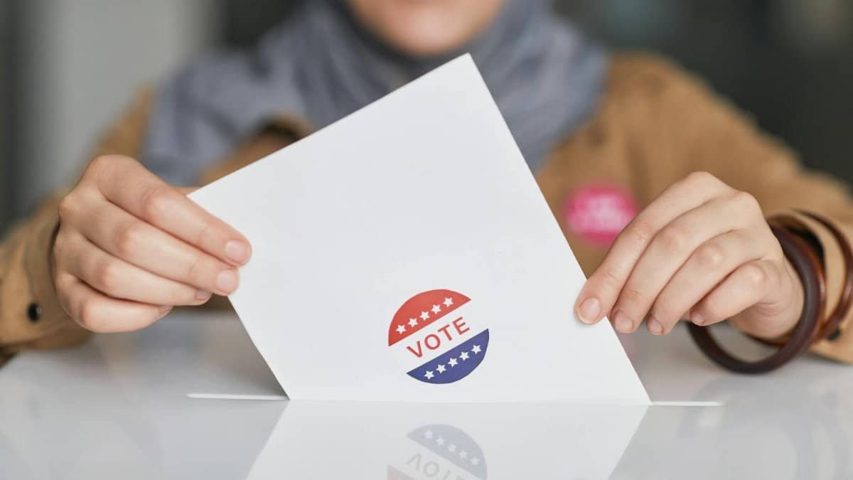 Close-up of hands holding a vote ballot, symbolizing election participation.