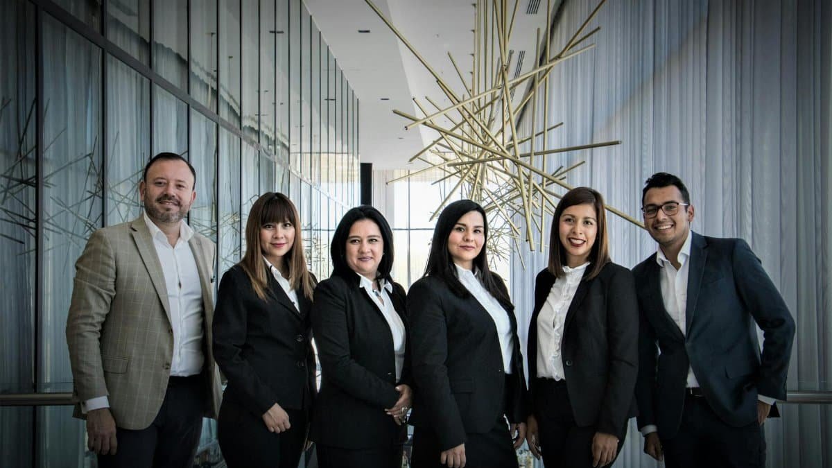 Diverse business team in formal attire posed in modern office.