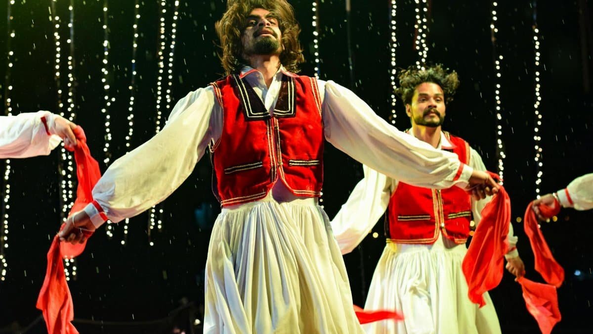 Vibrant dance performance with traditional costumes on stage, capturing dynamic motion and cultural expression.