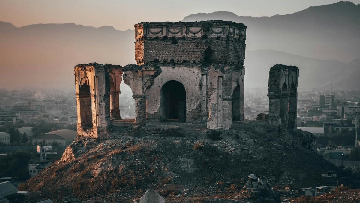 Aged ruins of King Nader Shah's tomb with a backdrop of Kabul city at dusk, displaying rich history.