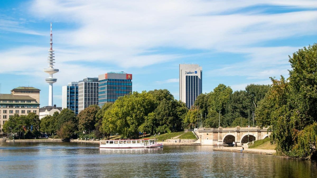 Scenic view of Heinrich Hertz Tower with river and lush trees in Hamburg, Germany.
