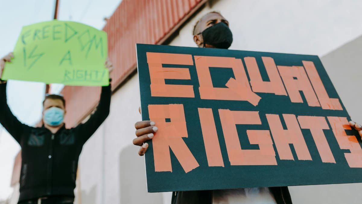Protesters holding signs for equal rights and freedom at a demonstration.