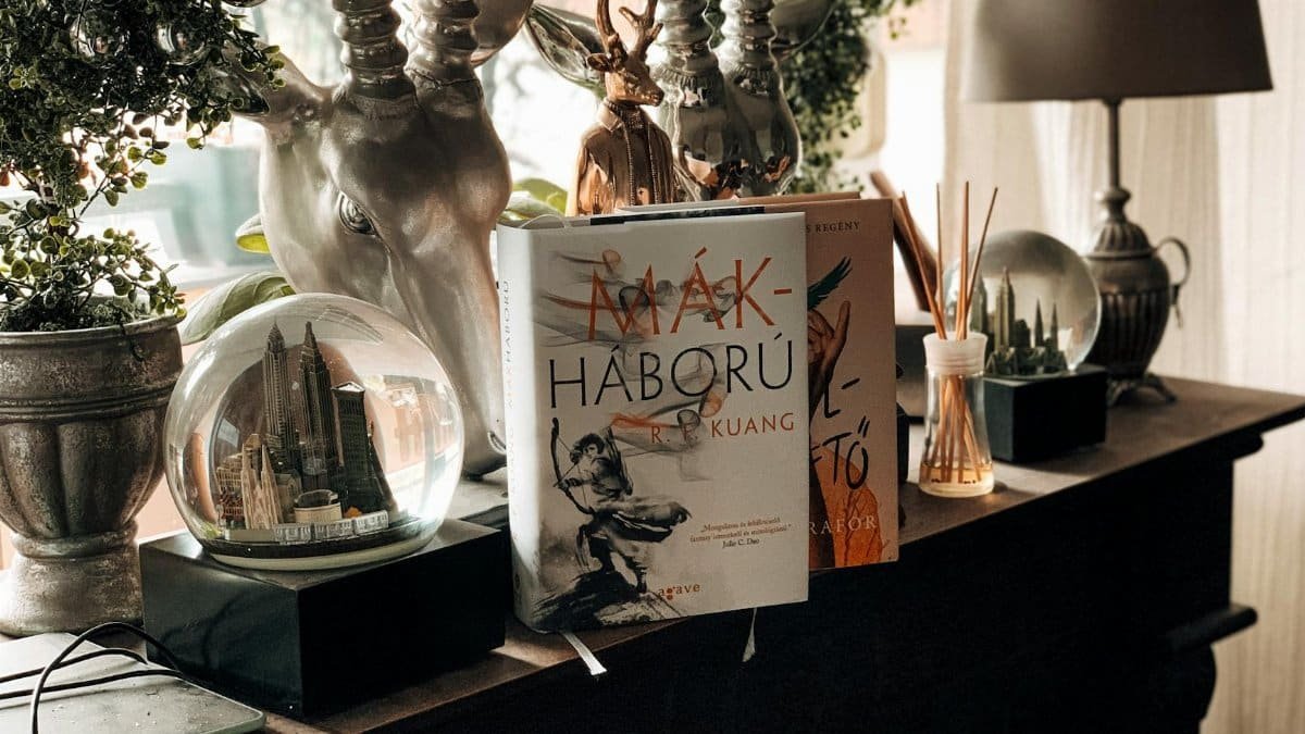 Stylish interior shelf featuring books, deer sculpture, and cityscape snow globes in soft natural light.
