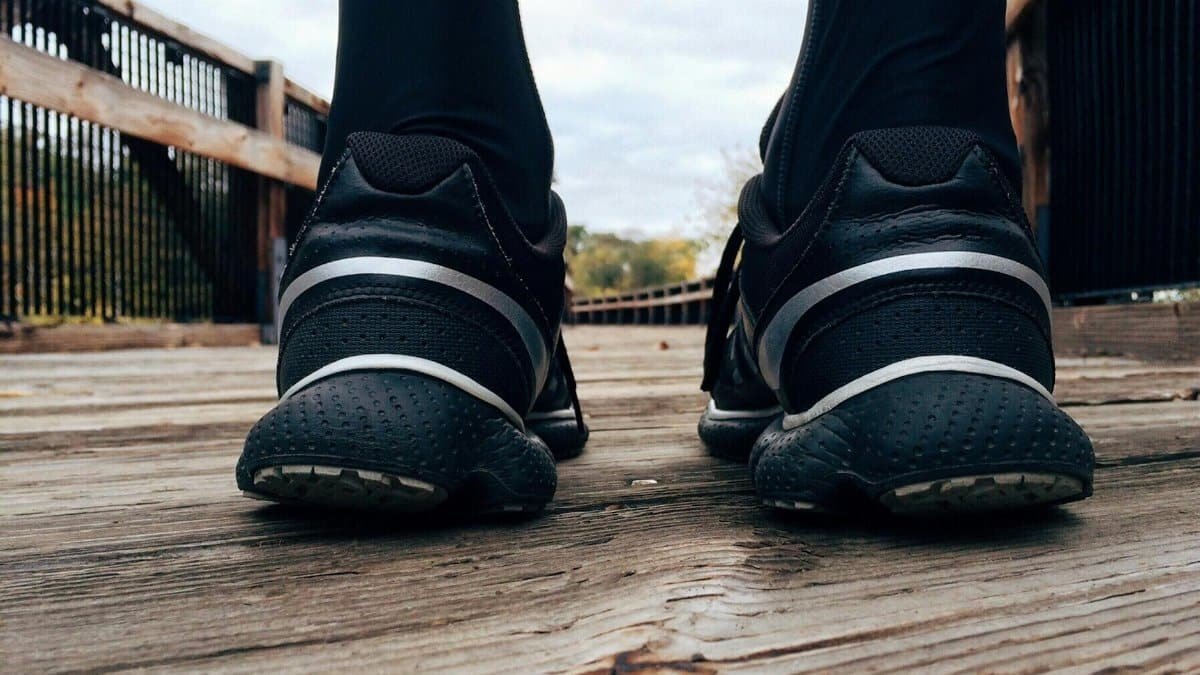 Close-up of athletic sneakers on a wooden bridge, capturing a runner's morning exercise routine.