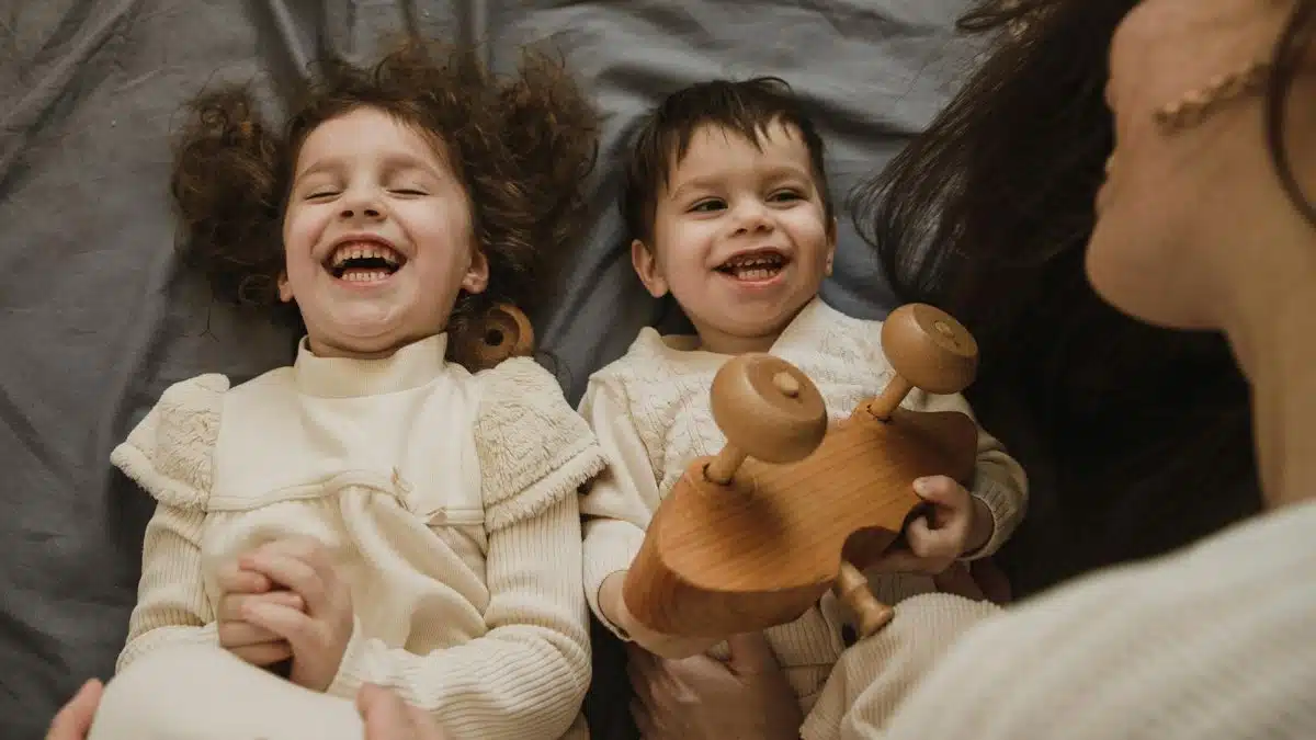 Happy family bonding time featuring a mother and her children enjoying a playful moment together indoors.