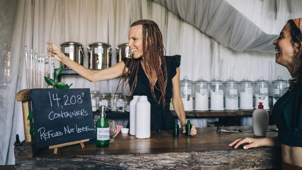 Eco-friendly store with staff refilling containers, promoting sustainable shopping.