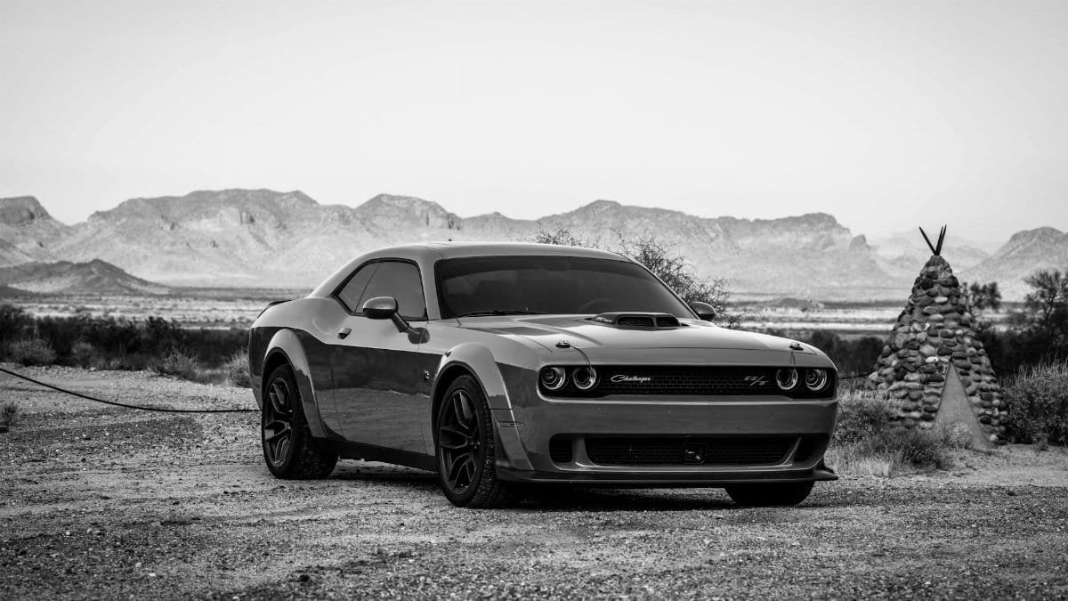 Monochrome photo of Dodge Challenger parked in scenic Arizona desert landscape.
