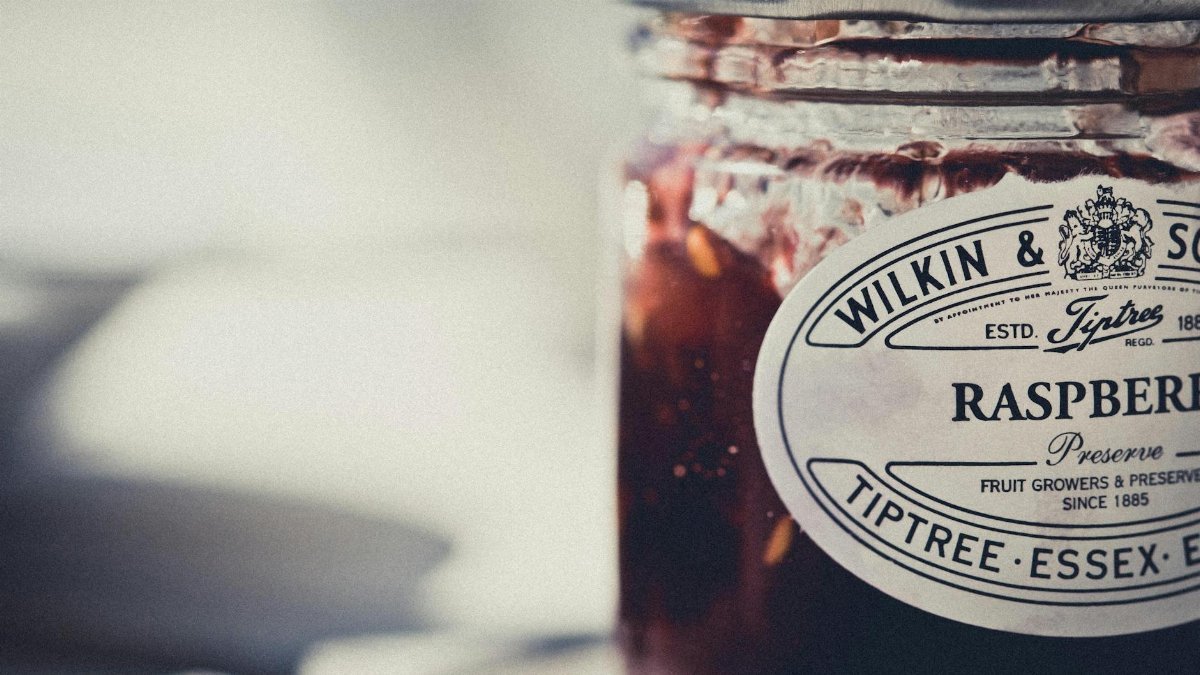 Artistic shot of a Tiptree raspberry preserve jar with vintage label.