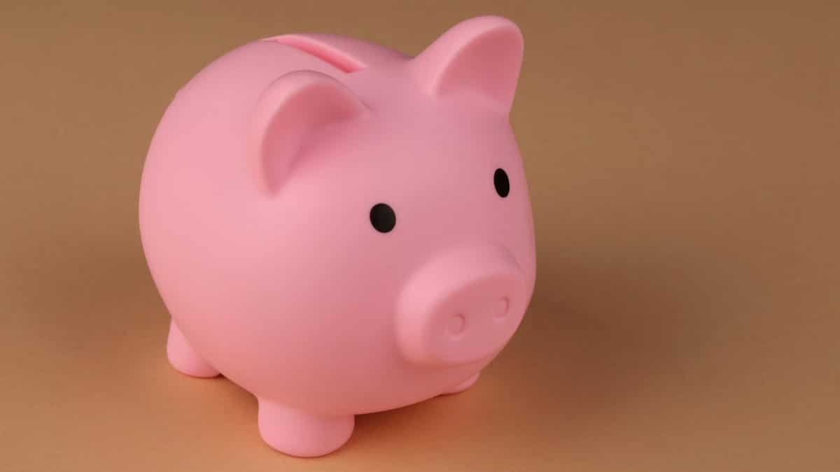 A pink piggy bank symbolizes savings and budgeting on a simple brown backdrop.