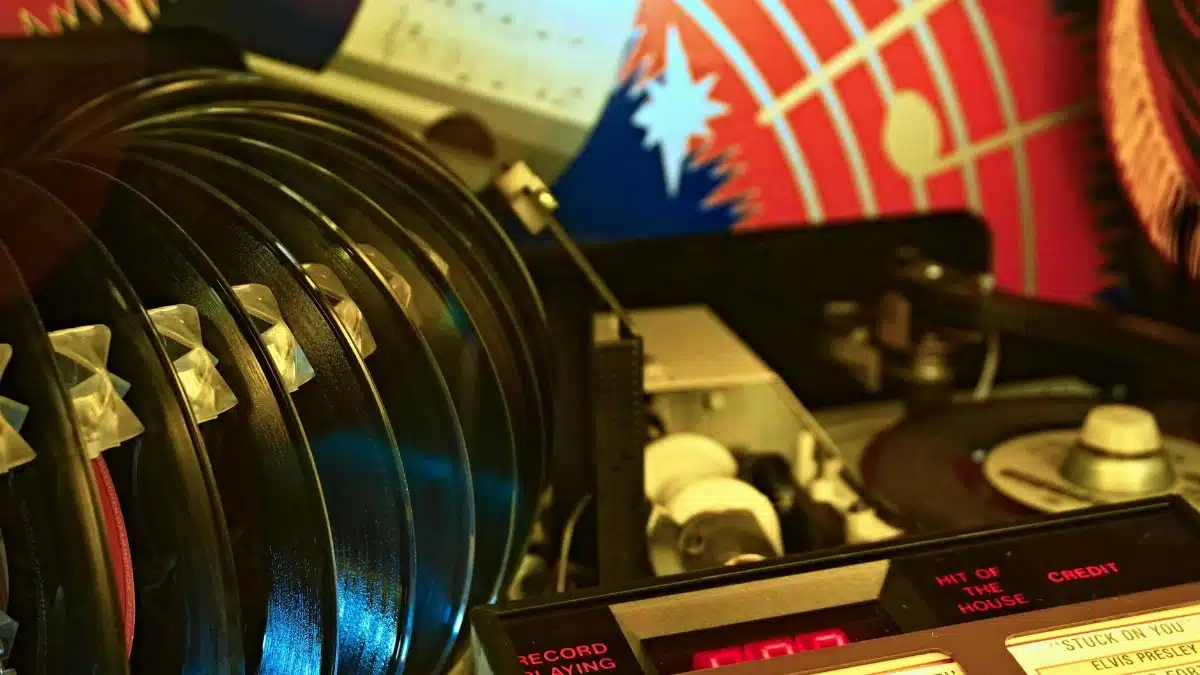 Close-up of a retro jukebox featuring vinyl records and classic hits playing in a vibrant setting.