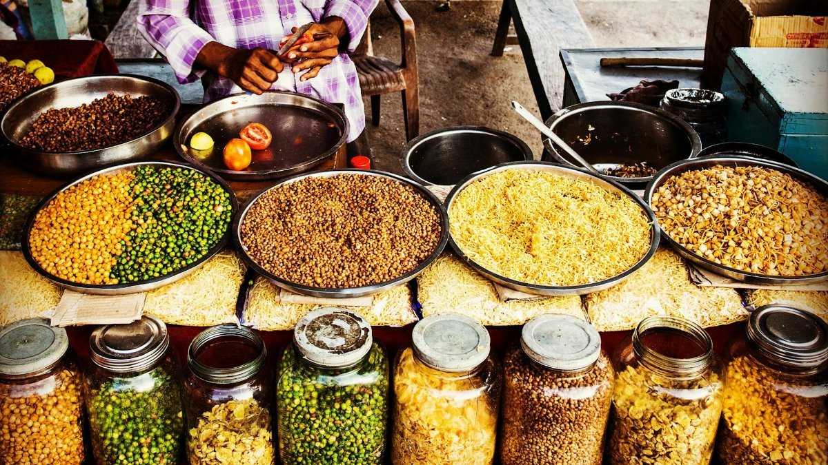 Colorful display of spices and legumes in a traditional Indian street market.
