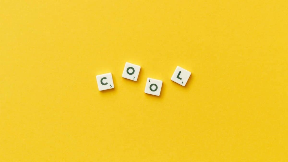Scrabble tiles spelling 'cool' on a vibrant yellow background. Perfect for conceptual designs.