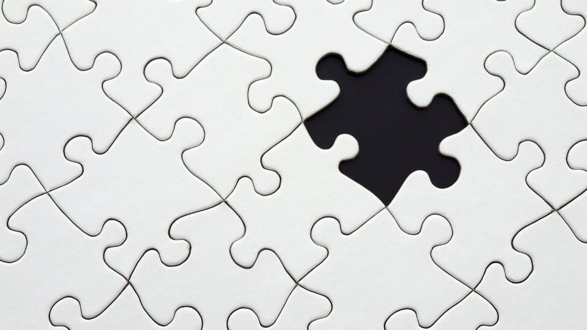 Close-up of an incomplete white puzzle with one missing piece, symbolizing challenge and strategy.