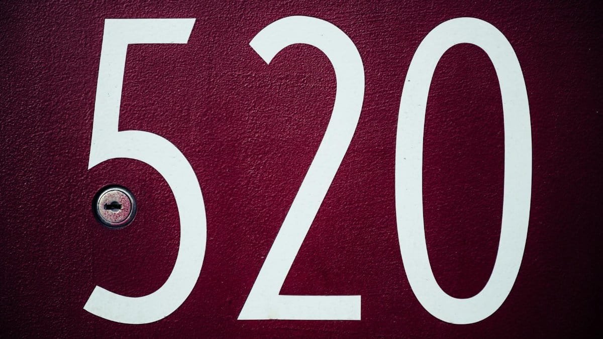 Close-up image of a red residential door with the number 520 and a keyhole.