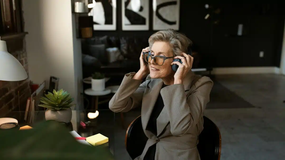 Mature woman enjoying music in modern home office setting. Stylish and relaxing.