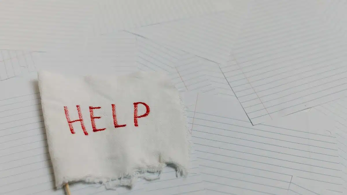 A flag with 'HELP' text on a lined paper background signifying distress or need for assistance.
