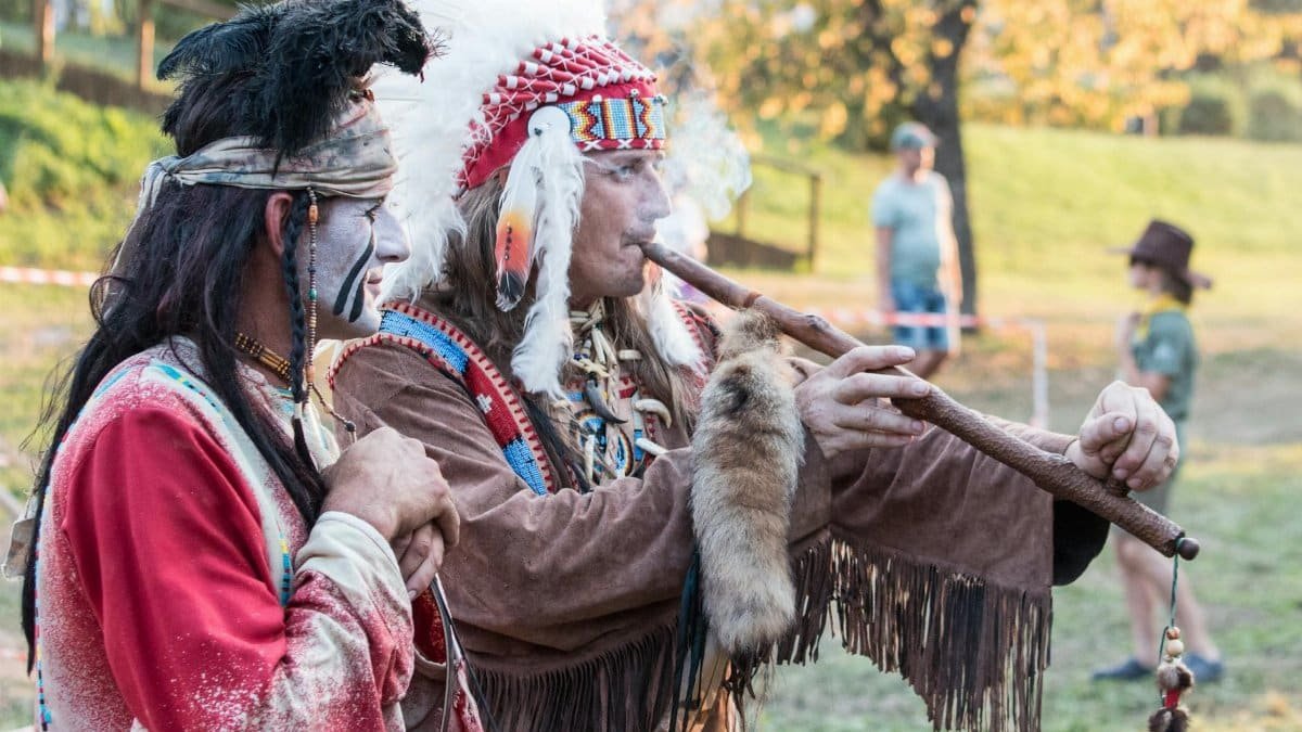 Traditional cultural ceremony featuring ceremonial wear and instruments in a Slovakian setting.