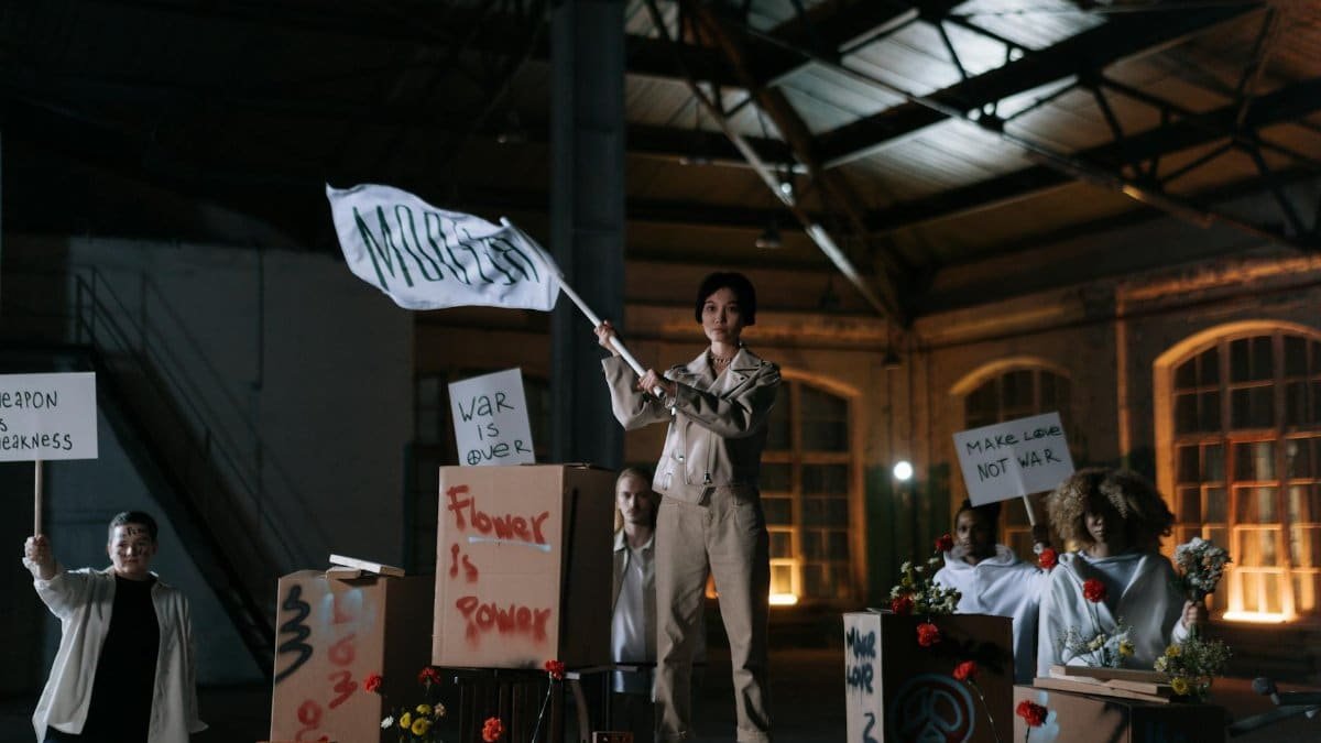 Group of diverse activists holding peaceful protest signs in an industrial setting, promoting nonviolence.