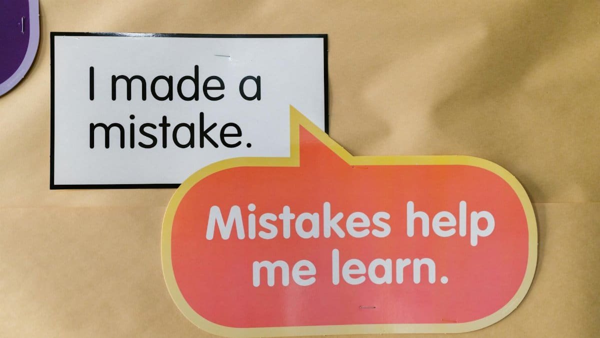 Bright square and speech bubble sign with motivational quotes about mistakes and learning.