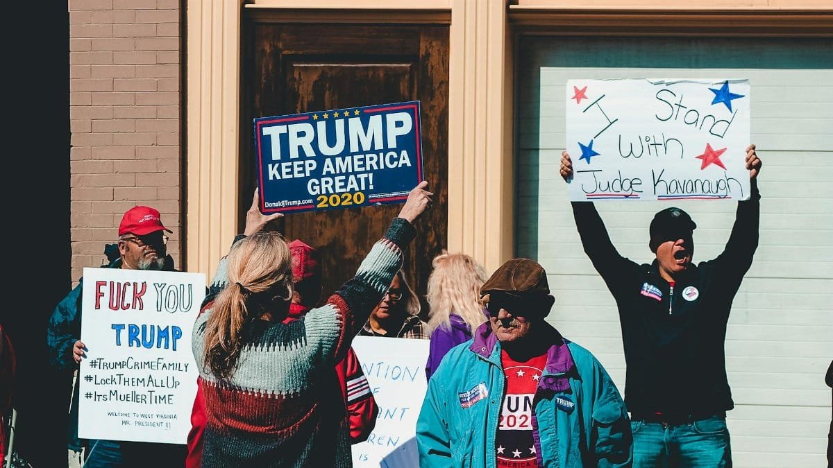 A group of people at a political rally in Wheeling, West Virginia, supporting different 2020 election campaigns.