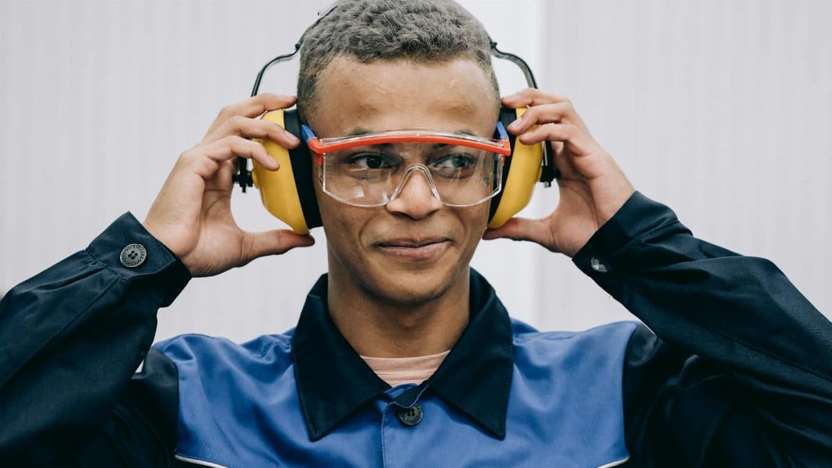 Confident worker adjusts safety gear, highlighting industrial safety practices.